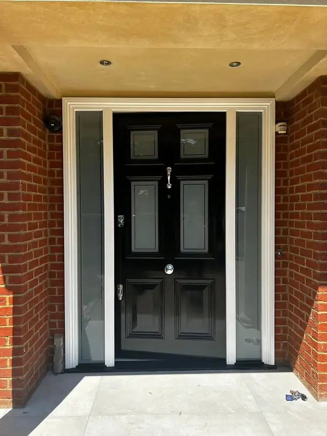 Black gloss panelled front door with white painted frame and side lights