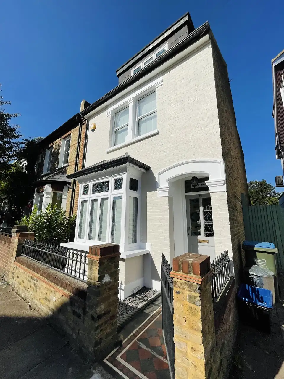Victorian terraced house in Richmond with freshly painted white render, bay window and front door, painted by JEM Decorators